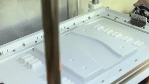 Off-road track mold is being vacuum-formed, showing the details of the mold and part of the forming process.