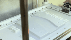 Off-road track mold is being vacuum-formed, showing the details of the mold and part of the forming process.