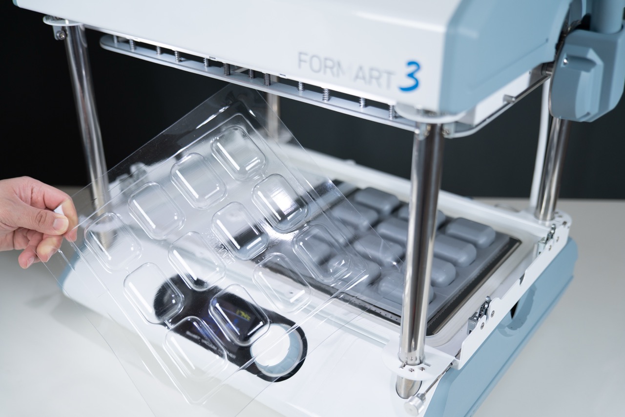 從真空成型機上拿起泡殼