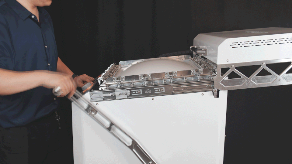 formova-demo-01 An operator lowers the front frame of a vacuum forming machine after forming a plastic sheet.